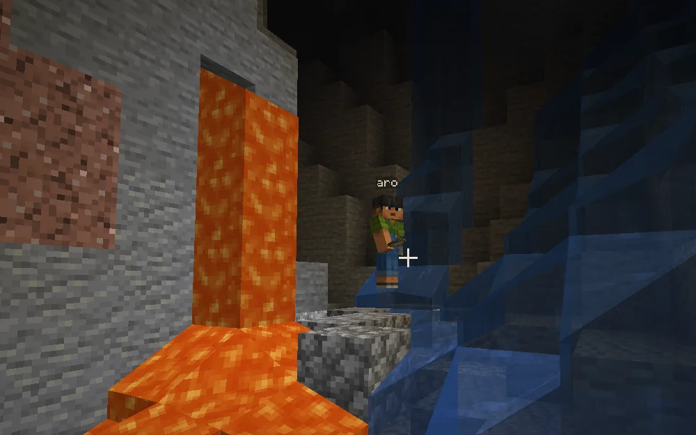 Minecraft screenshot: Aro wades through cave water beside a fall of lava.